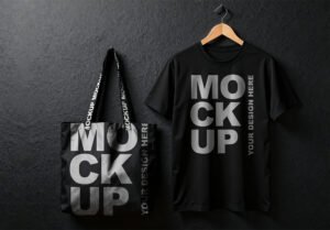 Thumbnail of a Professional Black T-Shirt and Tote Bag Mockup Hanging from a Wooden Hanger Against a Black Wall